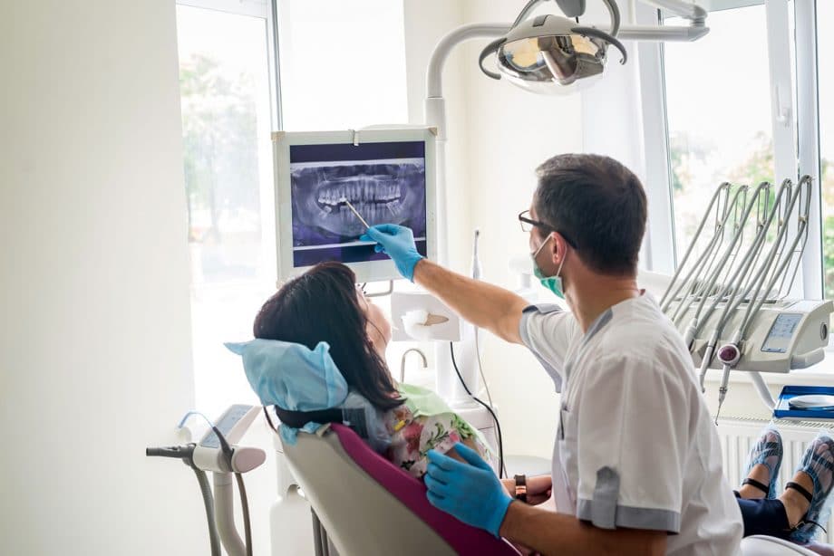 dentist showing xrays to patient in dental chair