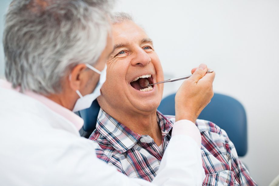 dentist looking inside dental patients mouth