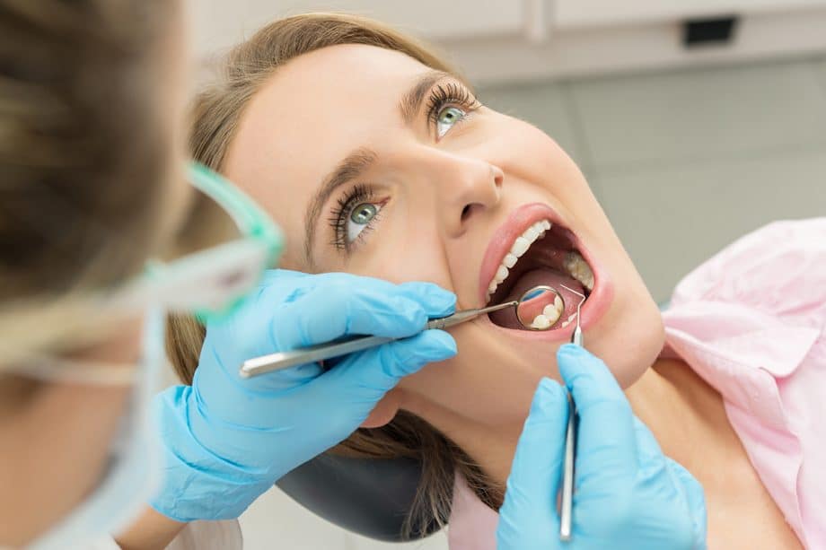 dentist checking woman's teeth for cavities