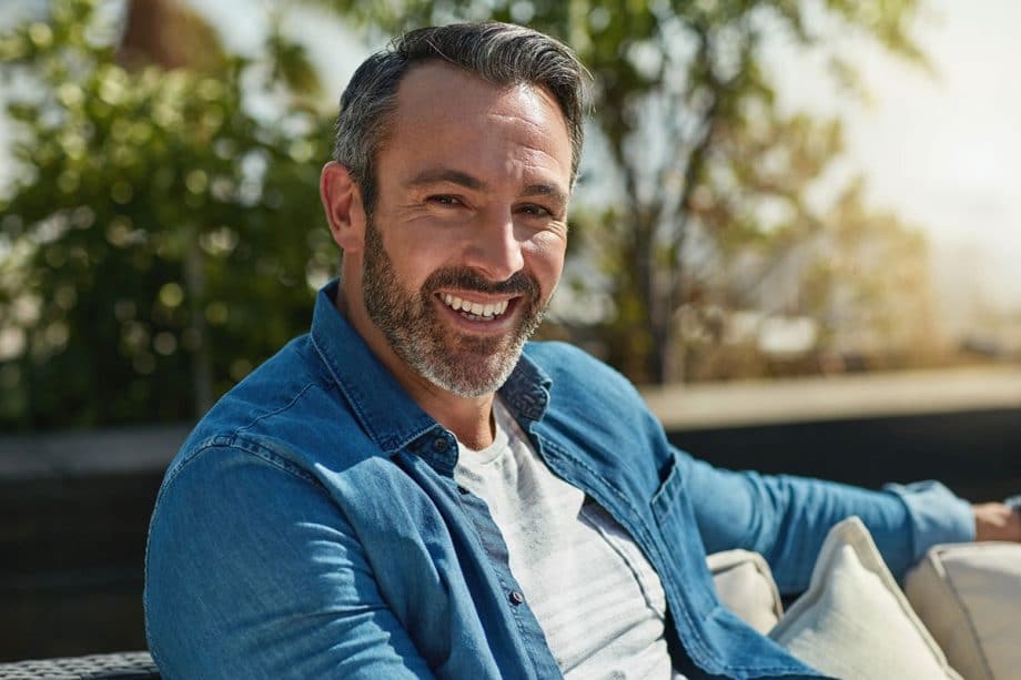 man sitting on couch and smiling
