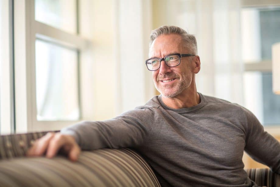 mature man sitting on couch and smiling