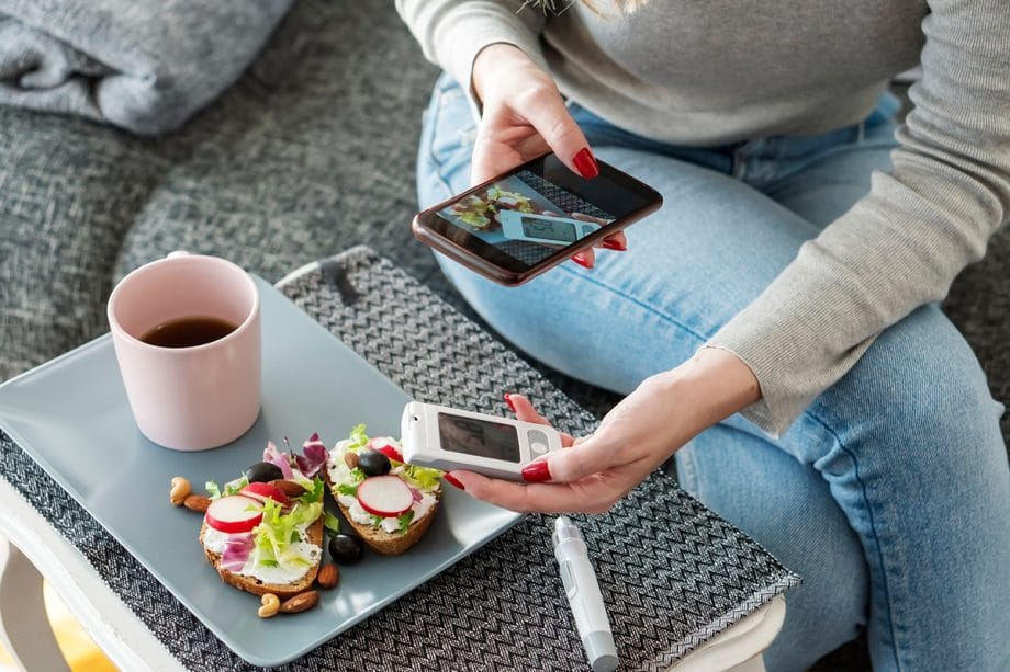 woman taking picture of a device next to her food